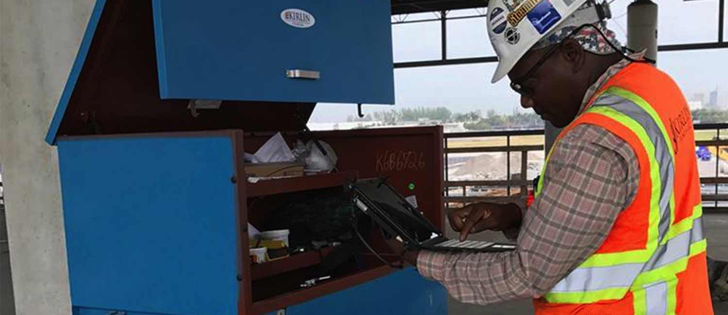 A worker uses a rugged tablet at a construction site