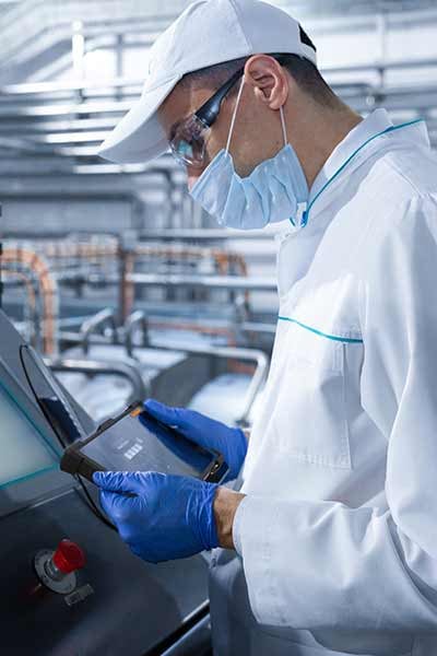 A worker uses a tablet in a sterile evironment