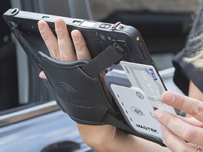 woman holding rugged tablet with integrated payment device and swiping credit card