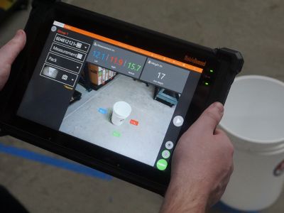 Person holding rugged tablet with xdim software to dimenison bucket