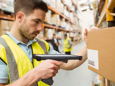 Male warehouse worker scanning barcode with handheld scanner