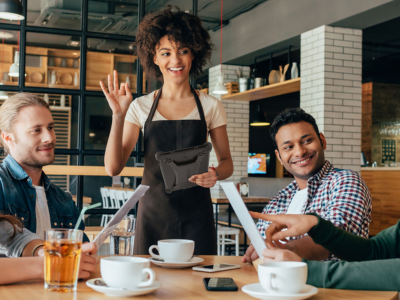 waitress holding rugged tablet taking cusomters order in restaurant