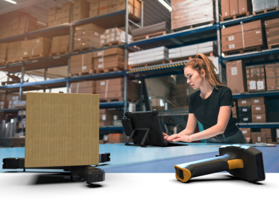 female in warehouse typing on rugged laptop with mobile scale and scan handle in foreground